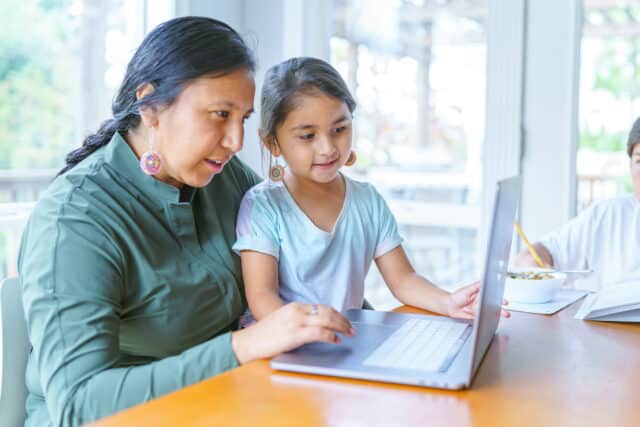 Image of Tribal community mother and daughter on computer